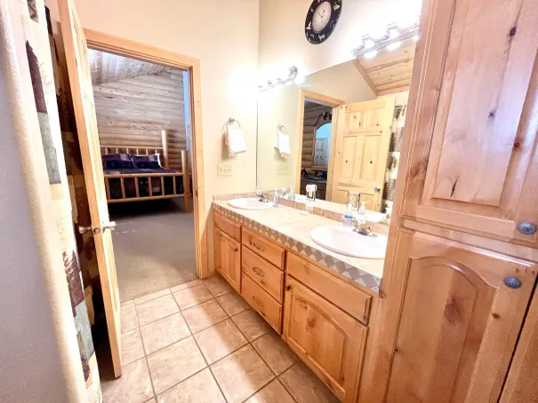 Master bathroom with tub/shower, toilet, and two vanities