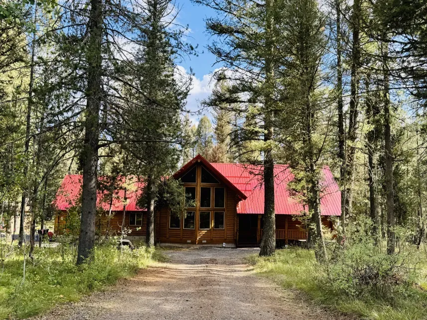 Lodgepole Pines Retreat cabin exterior in summer surrounded by pine trees